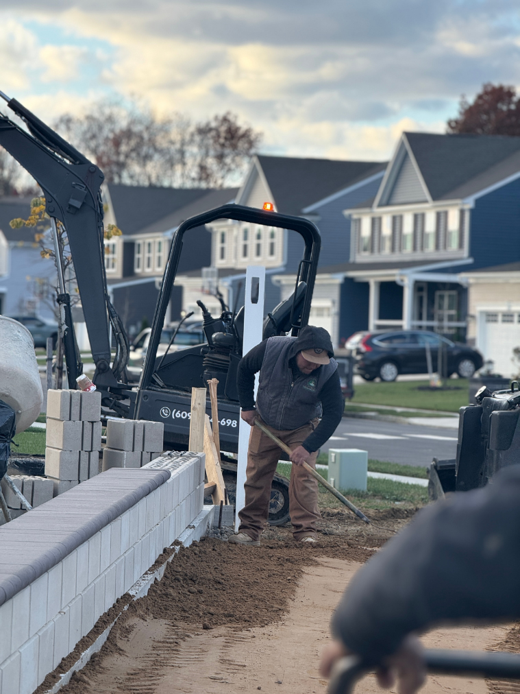 Worker digging residential driveway