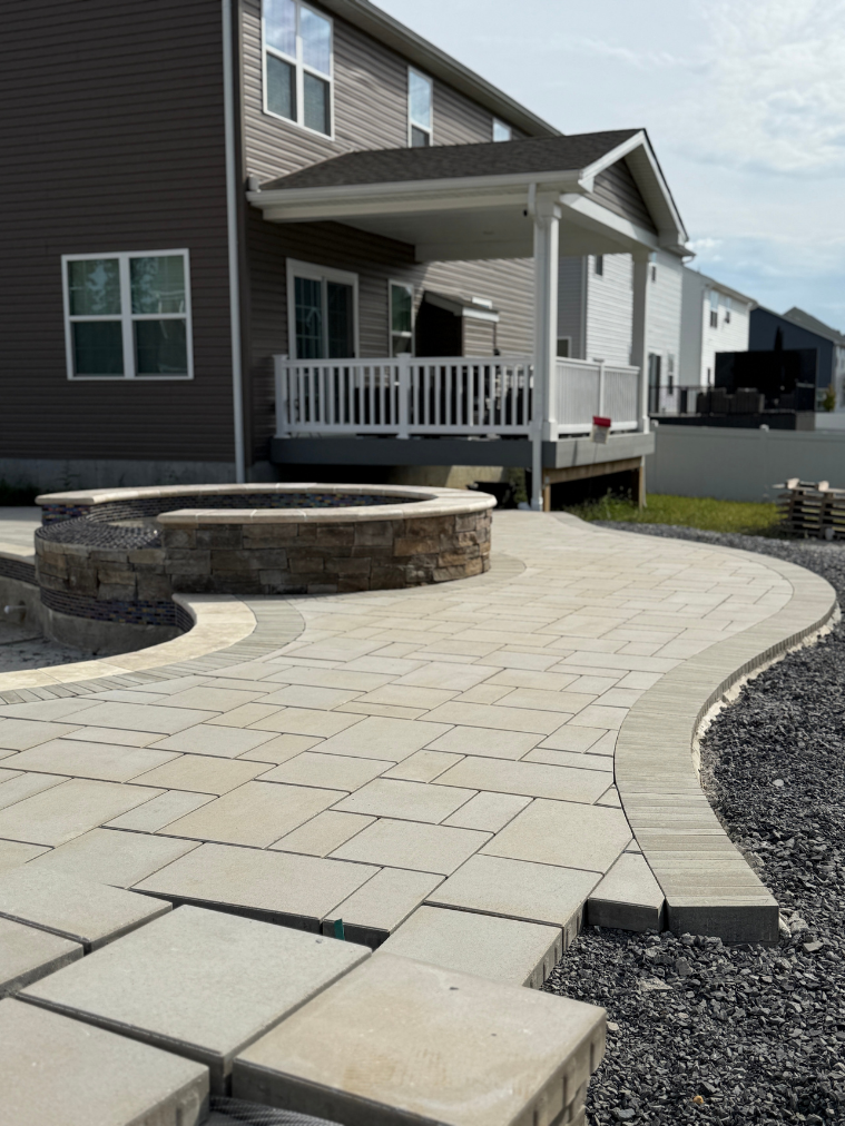 Curved paver patio with fire pit wall