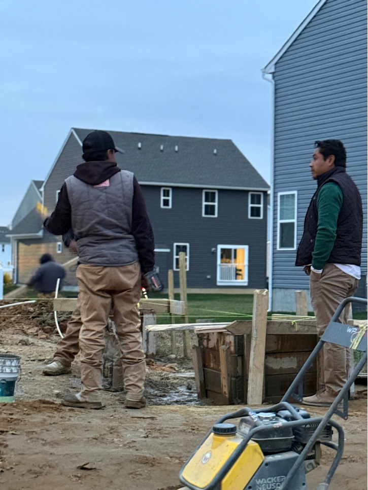 Crew reviewing foundation framing at dusk