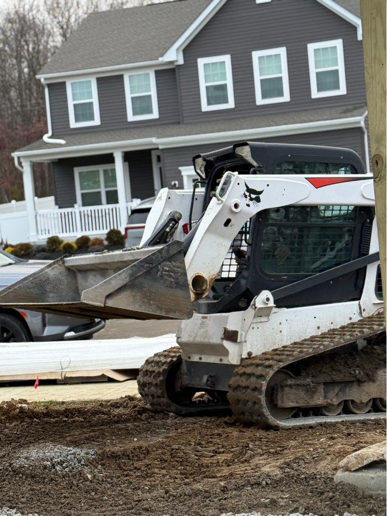 Skid steer working residential driveway