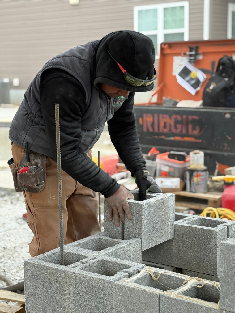 Worker stacking cinder blocks